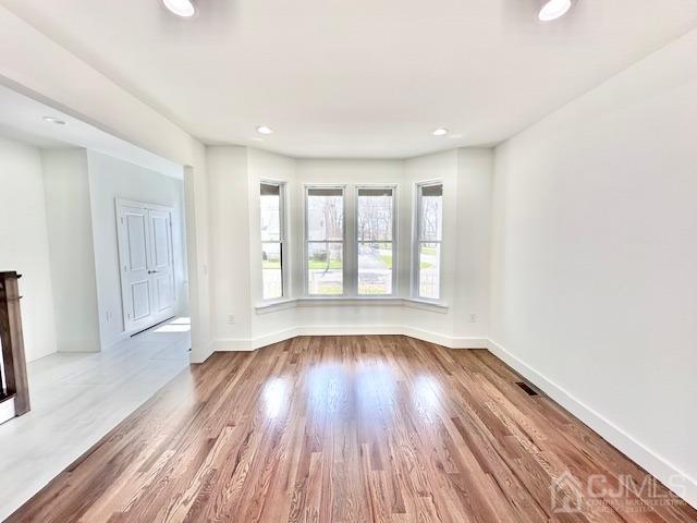 9 Melrose Ave, Sayreville, NJ 08879 - unfurnished living room with visible vents, baseboards, wood finished floors, and recessed lighting