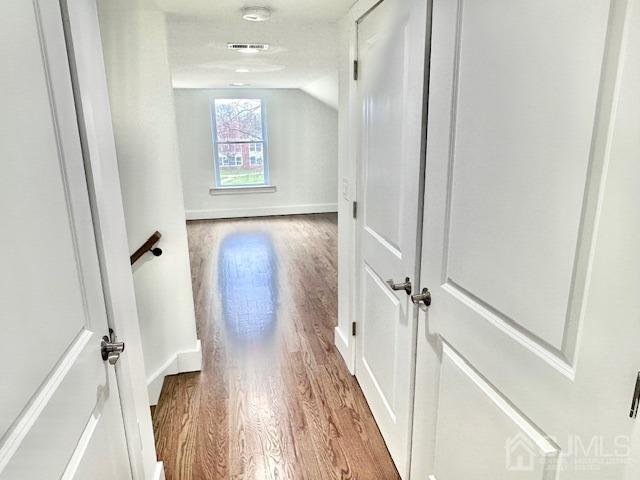 9 Melrose Ave, Sayreville, NJ 08879 - hallway featuring visible vents, baseboards, vaulted ceiling, and wood finished floors