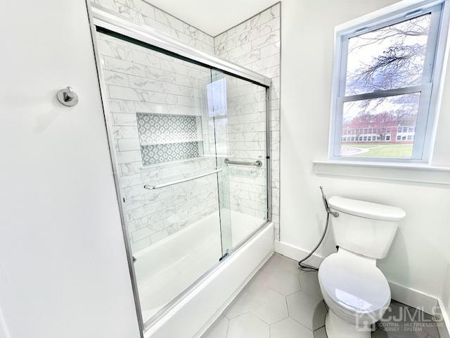 9 Melrose Ave, Sayreville, NJ 08879 - full bath featuring shower / bath combination with glass door, tile patterned flooring, toilet, and baseboards