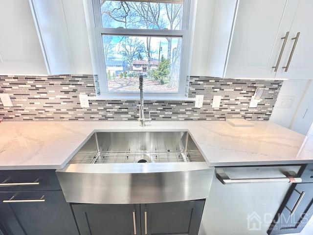 9 Melrose Ave, Sayreville, NJ 08879 - details with tasteful backsplash, light stone counters, white cabinetry, and a sink