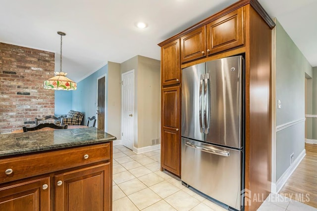 318 Ambrose Ave, Middlesex, NJ 08846 - kitchen featuring freestanding refrigerator, dark stone countertops, hanging light fixtures, light tile patterned floors, and brown cabinets