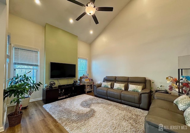 living room featuring recessed lighting, dark wood-type flooring, a ceiling fan, high vaulted ceiling, and baseboards