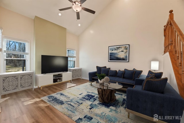 living area featuring ceiling fan, high vaulted ceiling, recessed lighting, wood finished floors, and baseboards