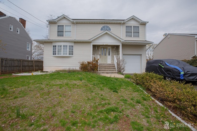traditional-style house with fence, a front yard, and a garage