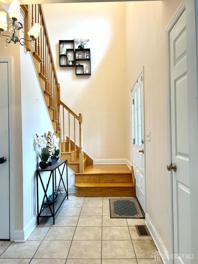 150 Montrose Ave, South Plainfield, NJ 07080 - entrance foyer with stairway, light tile patterned floors, a chandelier, and a high ceiling