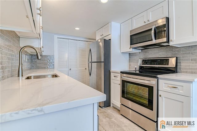 73 Chatham Dr Unit 73A, Monroe, NJ 08831 - kitchen with stainless steel appliances, a sink, tasteful backsplash, white cabinets, and light stone countertops