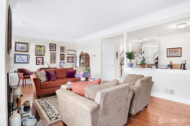 living room with light hardwood / wood-style floors and crown molding