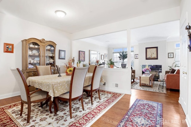 dining area featuring light wood-type flooring and ornamental molding