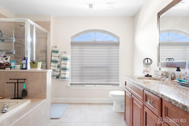 bathroom with tile patterned floors, a shower with door, vanity, and toilet