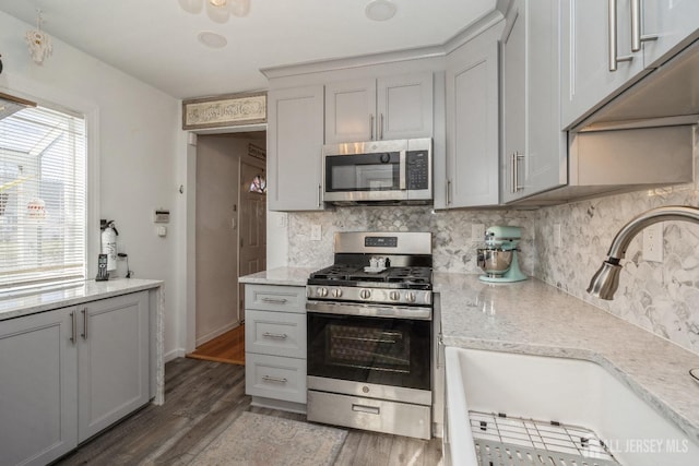 kitchen featuring appliances with stainless steel finishes, gray cabinetry, tasteful backsplash, and sink