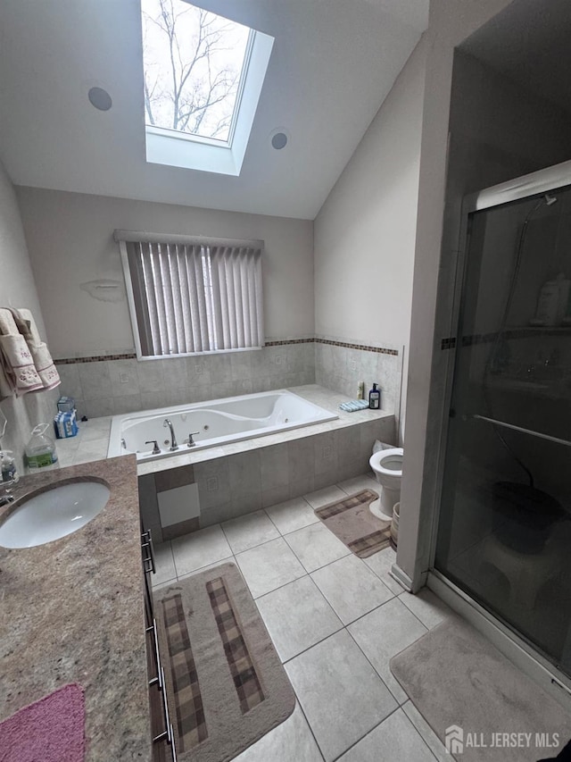 full bathroom featuring toilet, a wealth of natural light, lofted ceiling with skylight, and tile patterned floors