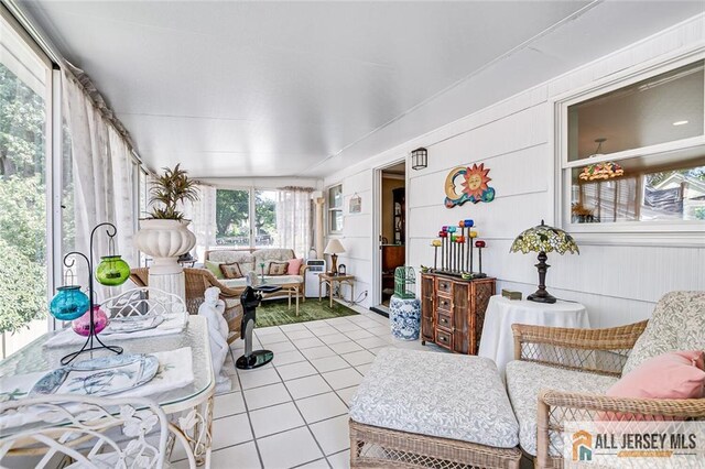 sunroom / solarium featuring tile patterned floors and an outdoor living space