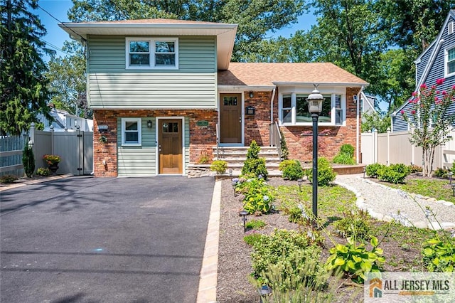 view of front of home with fence and brick siding