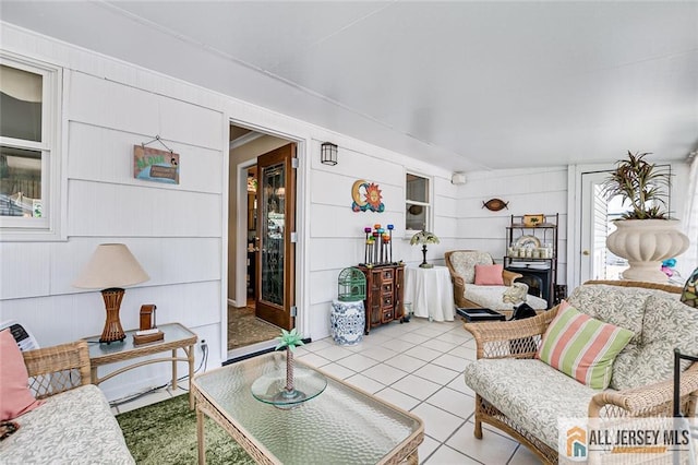living room featuring light tile patterned floors and wooden walls