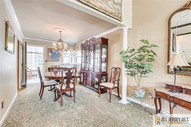 dining room featuring ornamental molding, a chandelier, baseboards, and decorative columns