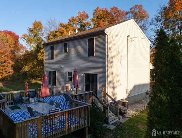 rear view of property with outdoor dining area, a wooden deck, and central AC unit