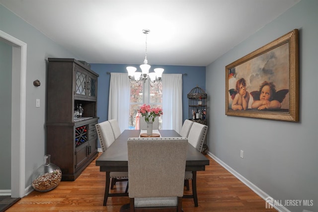 dining space featuring hardwood / wood-style flooring and a notable chandelier