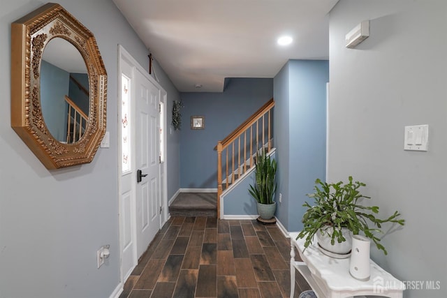 foyer entrance with stairway, baseboards, wood finished floors, and recessed lighting