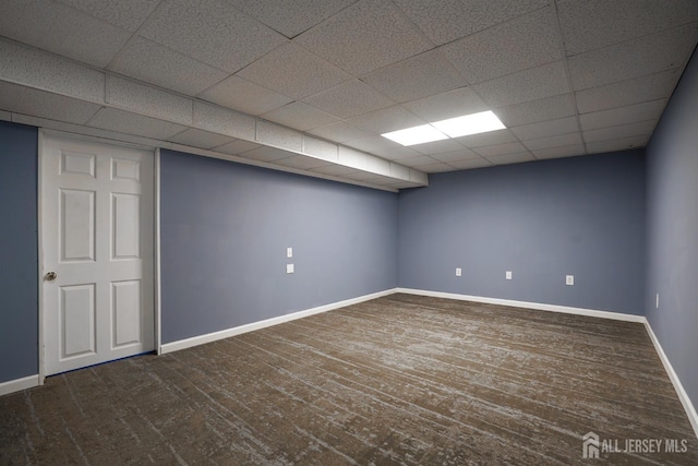 finished below grade area with wood finished floors, a paneled ceiling, and baseboards