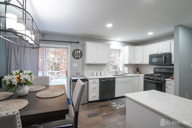 kitchen with black appliances, dark wood-style flooring, a sink, and plenty of natural light