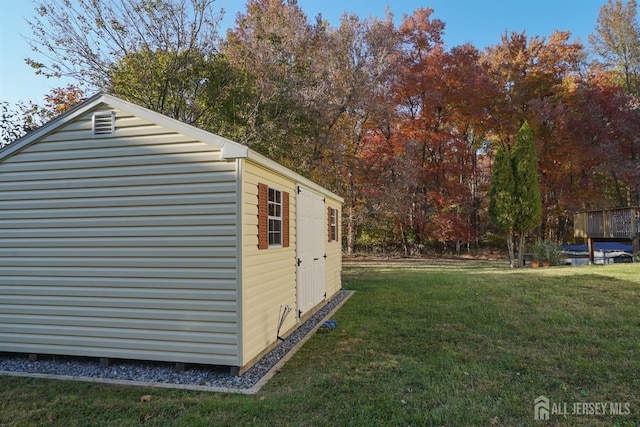view of side of property with a lawn and an outdoor structure