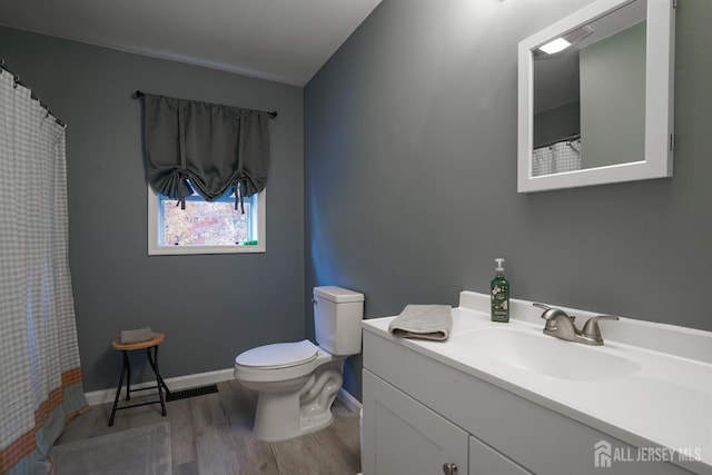 full bathroom featuring wood finished floors, baseboards, vanity, and toilet