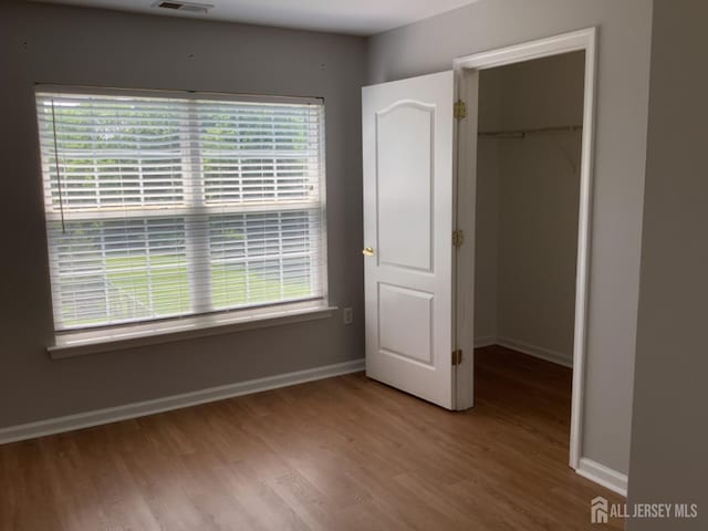 931 Cedar Ct, New Brunswick, NJ 08901 - unfurnished bedroom featuring wood finished floors, a closet, and a walk in closet