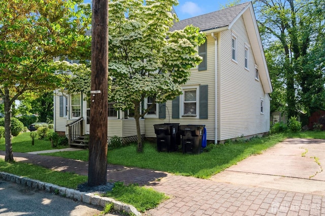 35 Kossman St, East Brunswick, NJ 08816 - view of front of house with entry steps, a front yard, and a shingled roof