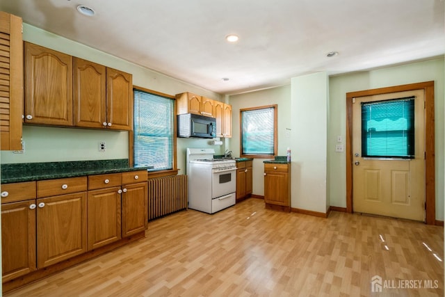 35 Kossman St, East Brunswick, NJ 08816 - kitchen featuring white range with gas stovetop, black microwave, light wood finished floors, brown cabinetry, and healthy amount of natural light