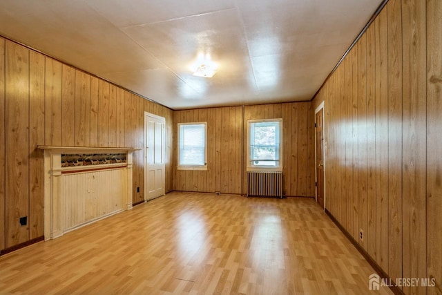 35 Kossman St, East Brunswick, NJ 08816 - unfurnished living room featuring radiator heating unit, light wood-style floors, and wooden walls