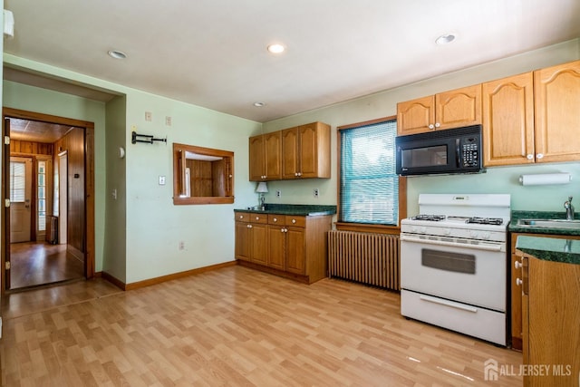 35 Kossman St, East Brunswick, NJ 08816 - kitchen with black microwave, white gas range, radiator, light wood finished floors, and dark countertops