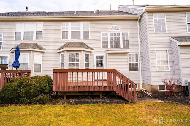 rear view of house featuring a lawn and a wooden deck