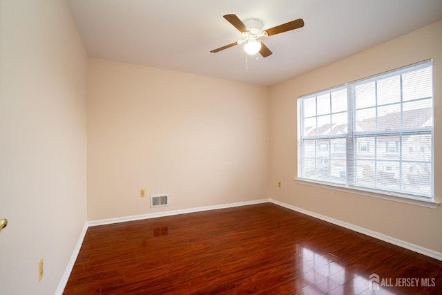 unfurnished room featuring visible vents, a ceiling fan, baseboards, and wood finished floors