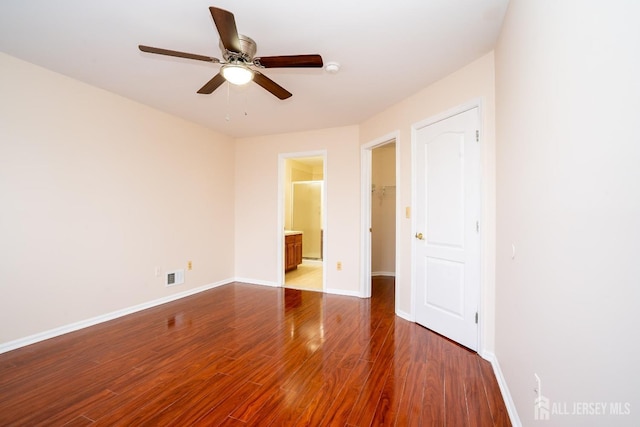 unfurnished bedroom with ceiling fan, ensuite bath, and hardwood / wood-style flooring