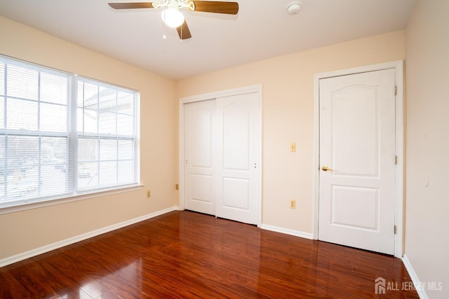 unfurnished bedroom with ceiling fan, a closet, baseboards, and wood finished floors