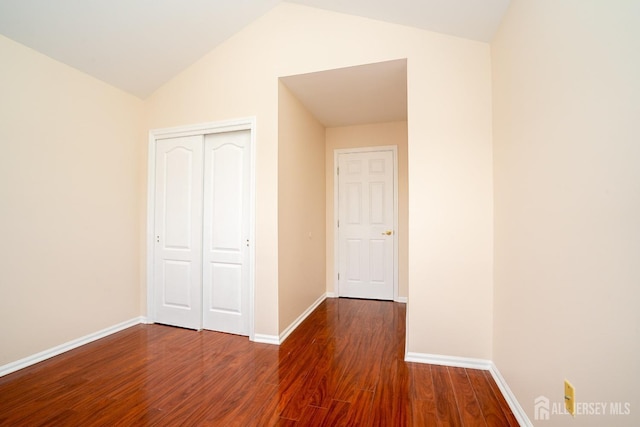 unfurnished bedroom with a closet, baseboards, and wood finished floors