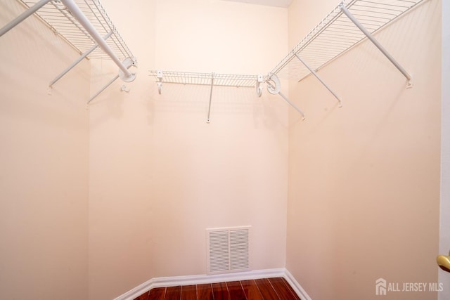 spacious closet featuring dark wood-style floors and visible vents