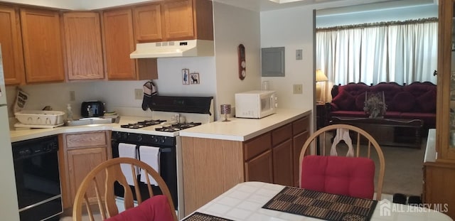 kitchen featuring dishwasher, light countertops, white microwave, under cabinet range hood, and range with gas cooktop