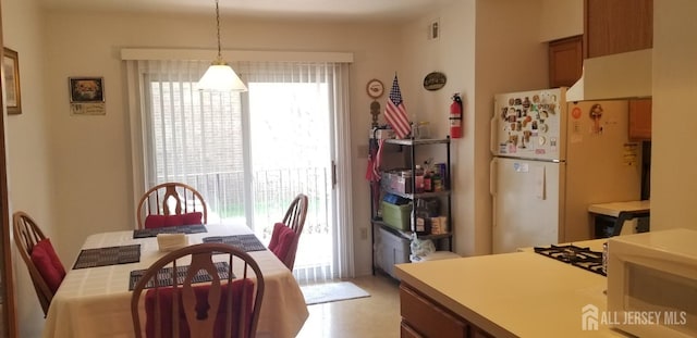 kitchen featuring light countertops, visible vents, freestanding refrigerator, and decorative light fixtures