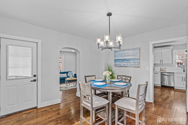 dining area with dark hardwood / wood-style flooring and a chandelier