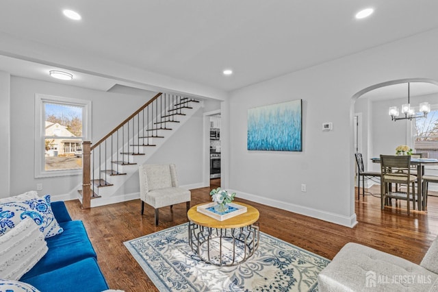 living room with dark wood-type flooring and a chandelier