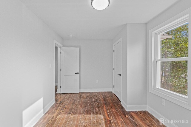 hallway with dark hardwood / wood-style flooring