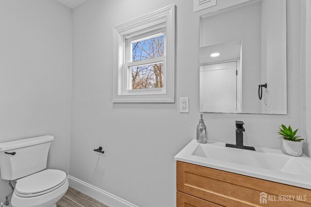 bathroom featuring hardwood / wood-style floors, toilet, and vanity