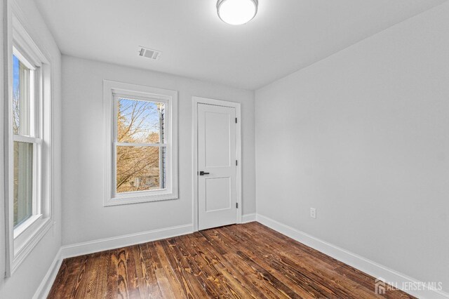 empty room with dark hardwood / wood-style flooring