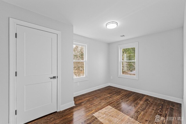 unfurnished room featuring dark hardwood / wood-style flooring