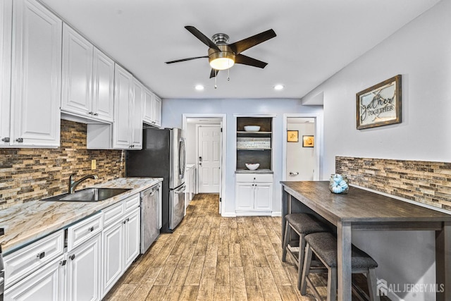 215 Kingsberry Dr, Franklin Twsp, NJ 08873 - kitchen with stainless steel appliances, a ceiling fan, white cabinets, decorative backsplash, and light wood finished floors