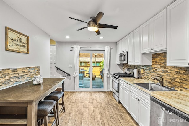 215 Kingsberry Dr, Franklin Twsp, NJ 08873 - kitchen with stainless steel appliances, a ceiling fan, light wood-style flooring, backsplash, and white cabinetry