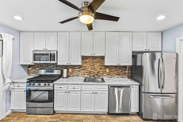 215 Kingsberry Dr, Franklin Twsp, NJ 08873 - kitchen featuring appliances with stainless steel finishes, ceiling fan, white cabinetry, backsplash, and light wood-style flooring