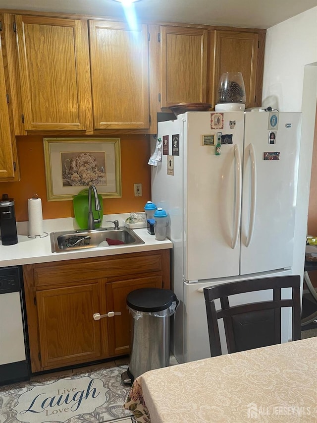 4215 Birchwood Ct, North Brunswick, NJ 08902 - kitchen featuring a sink, freestanding refrigerator, dishwashing machine, light countertops, and brown cabinetry
