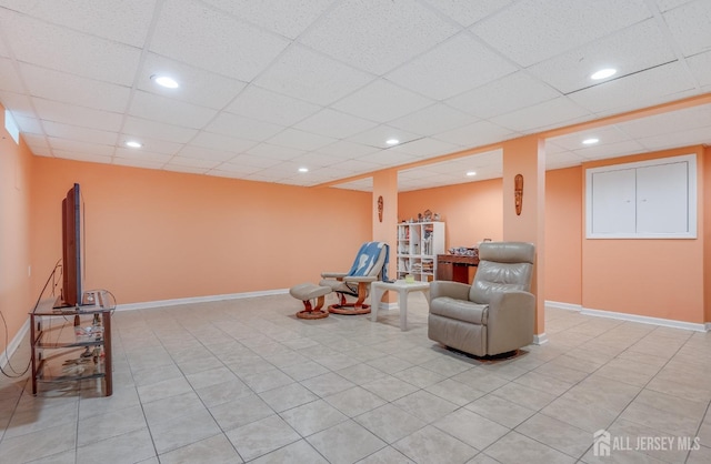 living area with recessed lighting, a paneled ceiling, baseboards, and light tile patterned floors